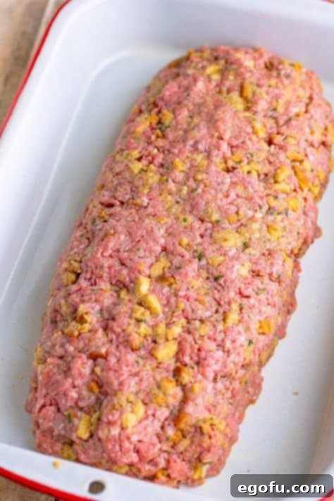 The raw meatloaf mixture, perfectly shaped into an even oval, resting in the baking dish, ready for the oven.