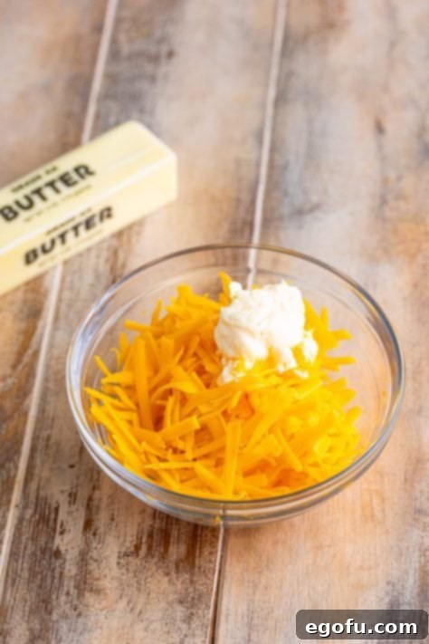 A small bowl of mayo and shredded cheese.