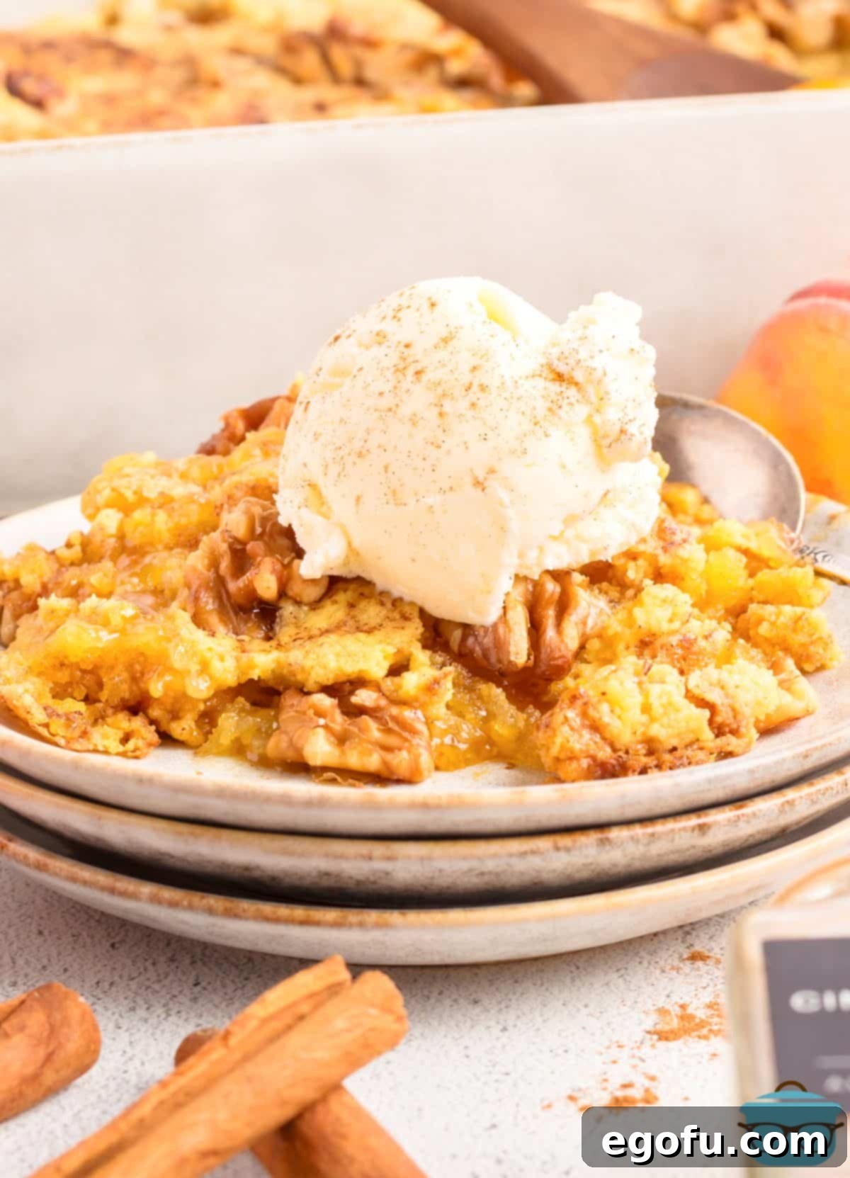 A small dessert plate of Peach Dump Cake with a scoop of vanilla ice cream.