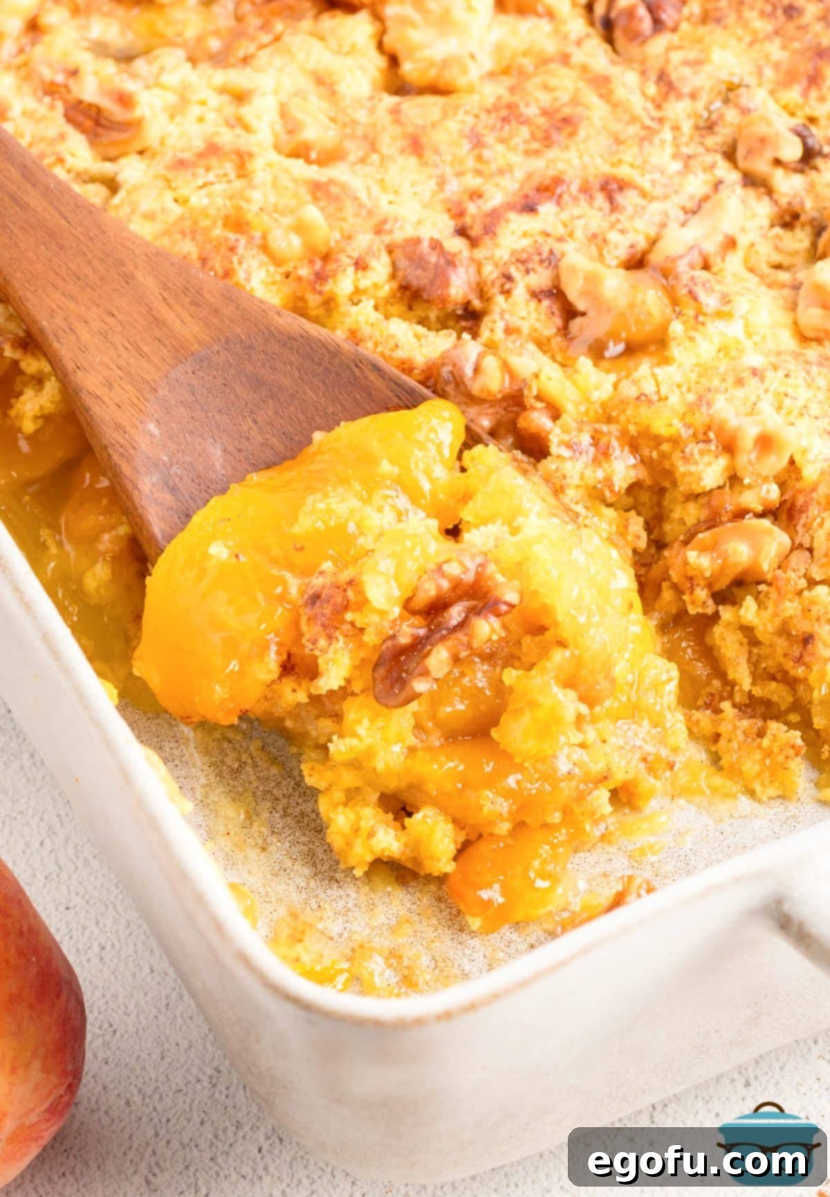 A baking dish with a scoop of Peach Dump Cake.