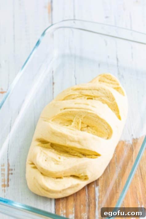 An unbaked loaf of raw bread dough that's sliced.