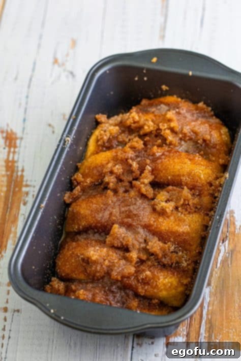 A cinnamon and sugar covered loaf of raw bread.
