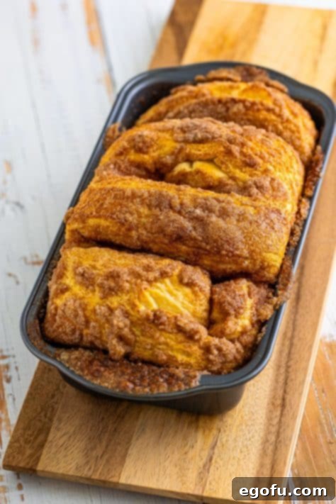 A loaf of unbaked Cinnamon Bread that has risen in a baking pan.