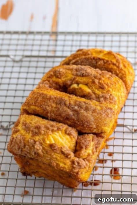 A baked loaf of Cinnamon Bread on a wire rack.