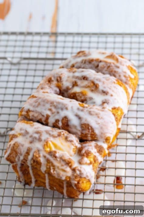 A glazed loaf of Dollywood Cinnamon Bread on a wire rack.