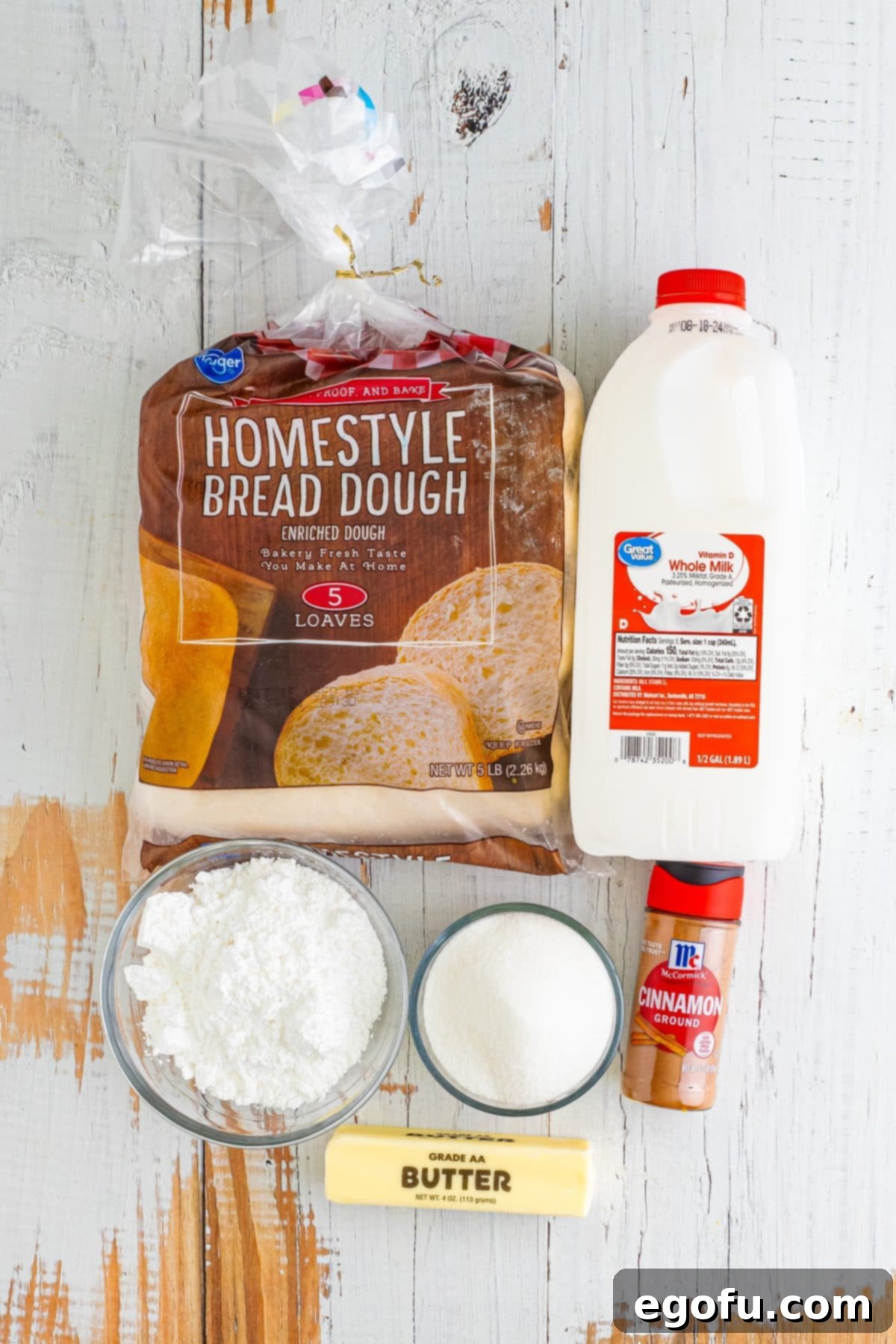 A flat lay of the simple ingredients needed for Dollywood Cinnamon Bread: frozen bread loaves, whole milk, butter, sugar, cinnamon, and powdered sugar.
