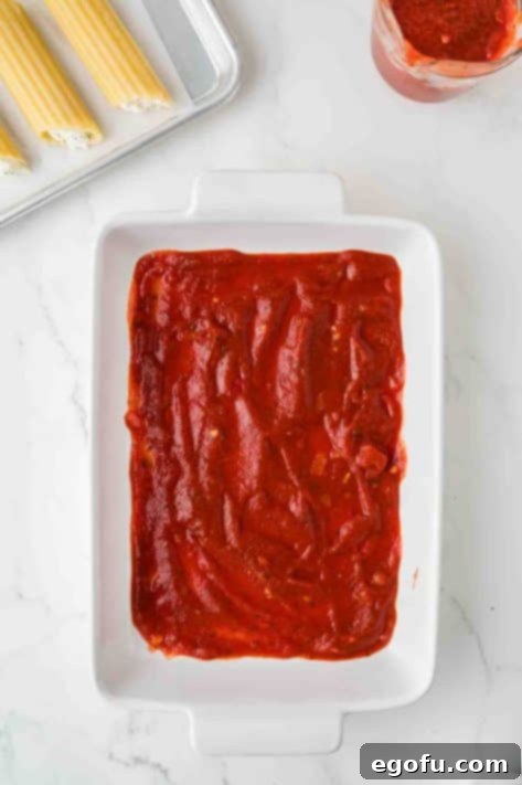 Effortless Manicotti 10 Marinara sauce in a baking dish.
