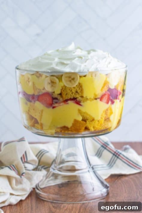 Party Perfect Bowl Cake 20 A punch bowl with a layered cake made of cake, pudding, strawberries, bananas, pineapples and whipped topping.