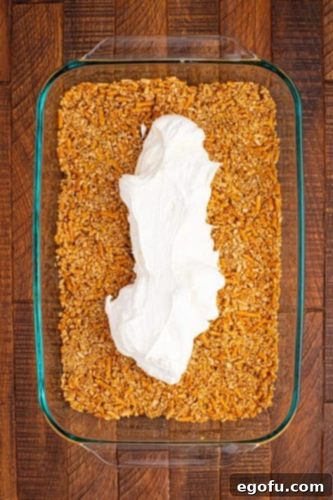 Cream cheese layer dumped on pretzel layer.