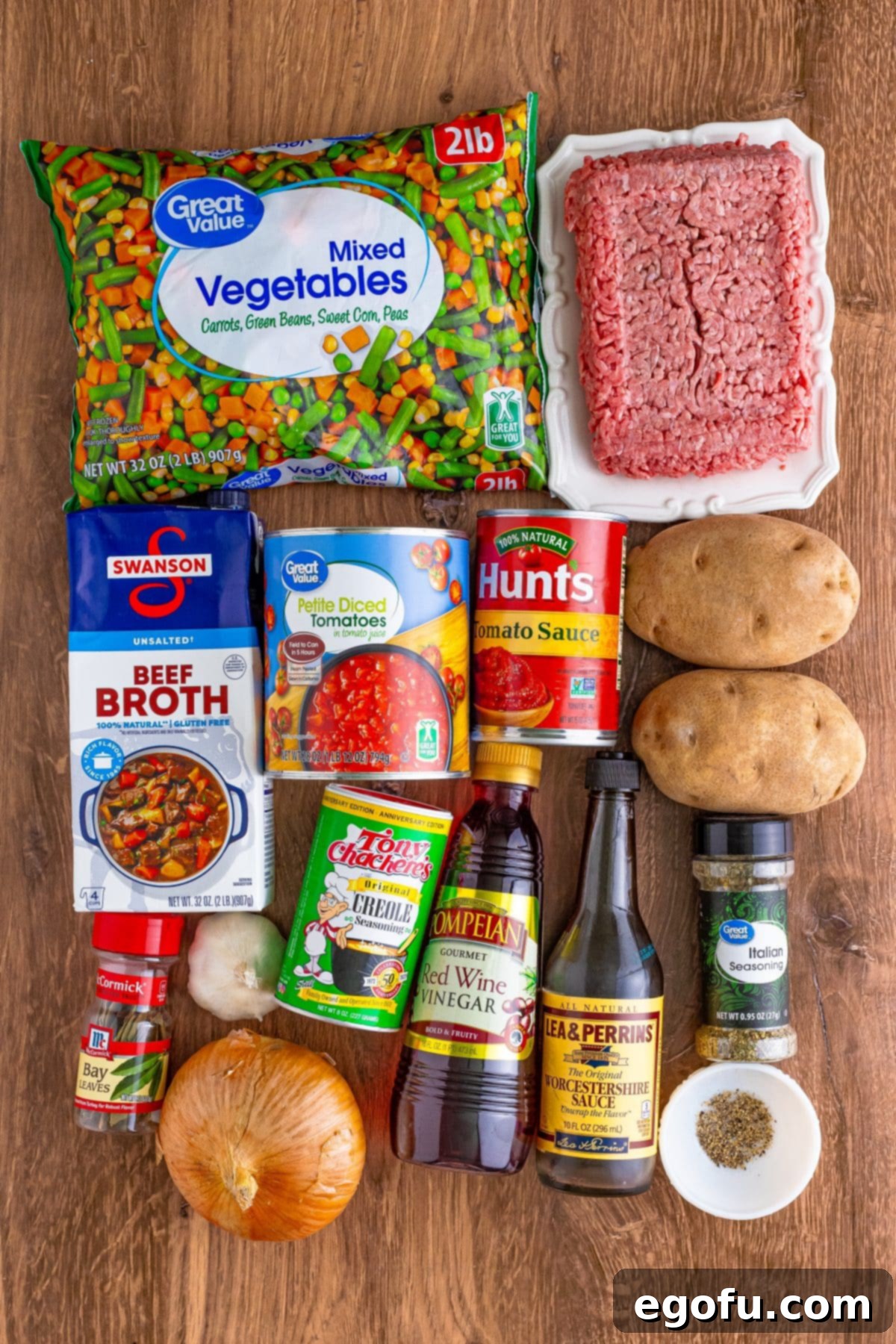 Lean ground beef, sweet onion, cloves garlic, beef broth, petite diced tomatoes, tomato sauce, russet potatoes, Worcestershire sauce, red wine vinegar, dried Italian seasoning, creole seasoning, black pepper, bay leaf, and frozen mixed vegetables.