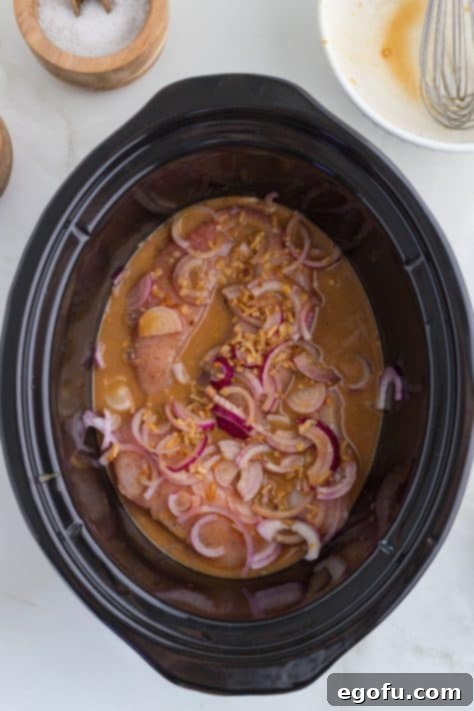 Chicken, onion, onion soup, beef broth, and Dijon mustard in a Crock pot.
