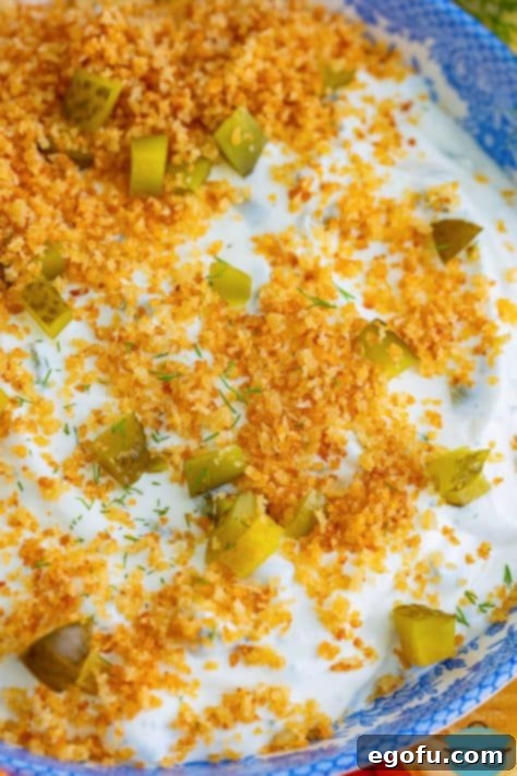 A top-down view of the finished Fried Pickle Dip in a serving bowl, garnished with golden breadcrumbs.