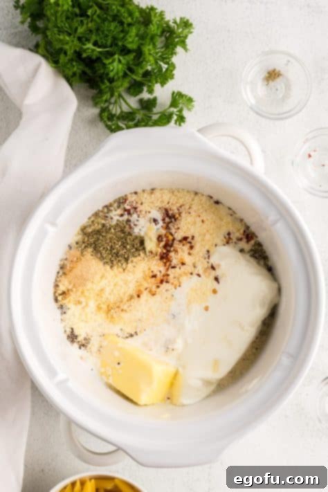 Creamy Slow Cooker Garlic Parmesan Chicken Pasta 9 All the initial ingredients for Garlic Parmesan Chicken Pasta in the Crock Pot before cooking.