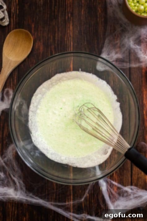 Bewitching Brew Hot Chocolate 11 A bowl containing heavy cream, powdered sugar, and lime Jell-O powder, ready to be whipped.