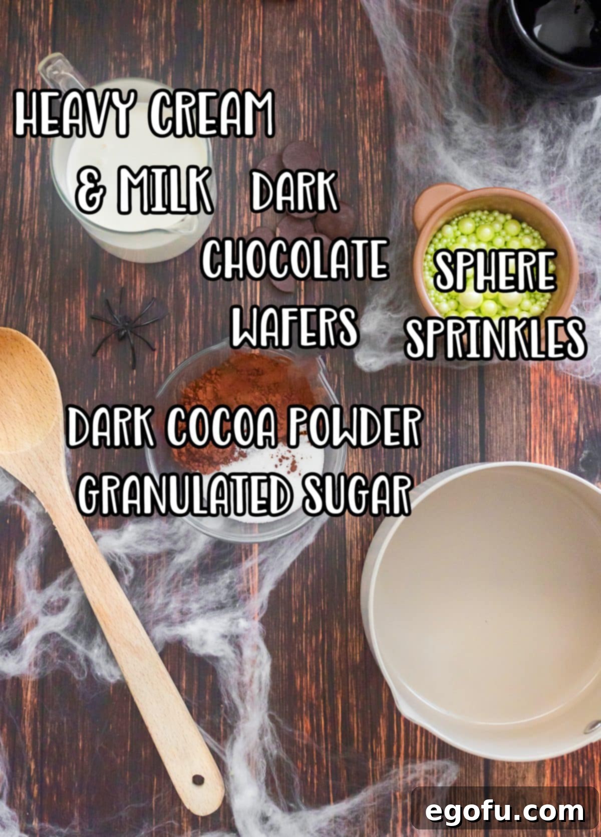 Bewitching Brew Hot Chocolate 4 A flat lay of all the Witches Brew Hot Chocolate ingredients: green sphere sprinkles, lime Jell-O powder, heavy cream, powdered sugar, whole milk, dark cocoa powder, and dark chocolate melting wafers.