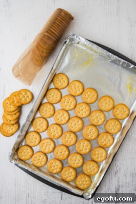 Decadent Strawberry Chocolate Bark 10 Ritz crackers on an aluminum foil lined sheet.