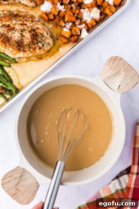 A bowl of gravy on a sheet pan.