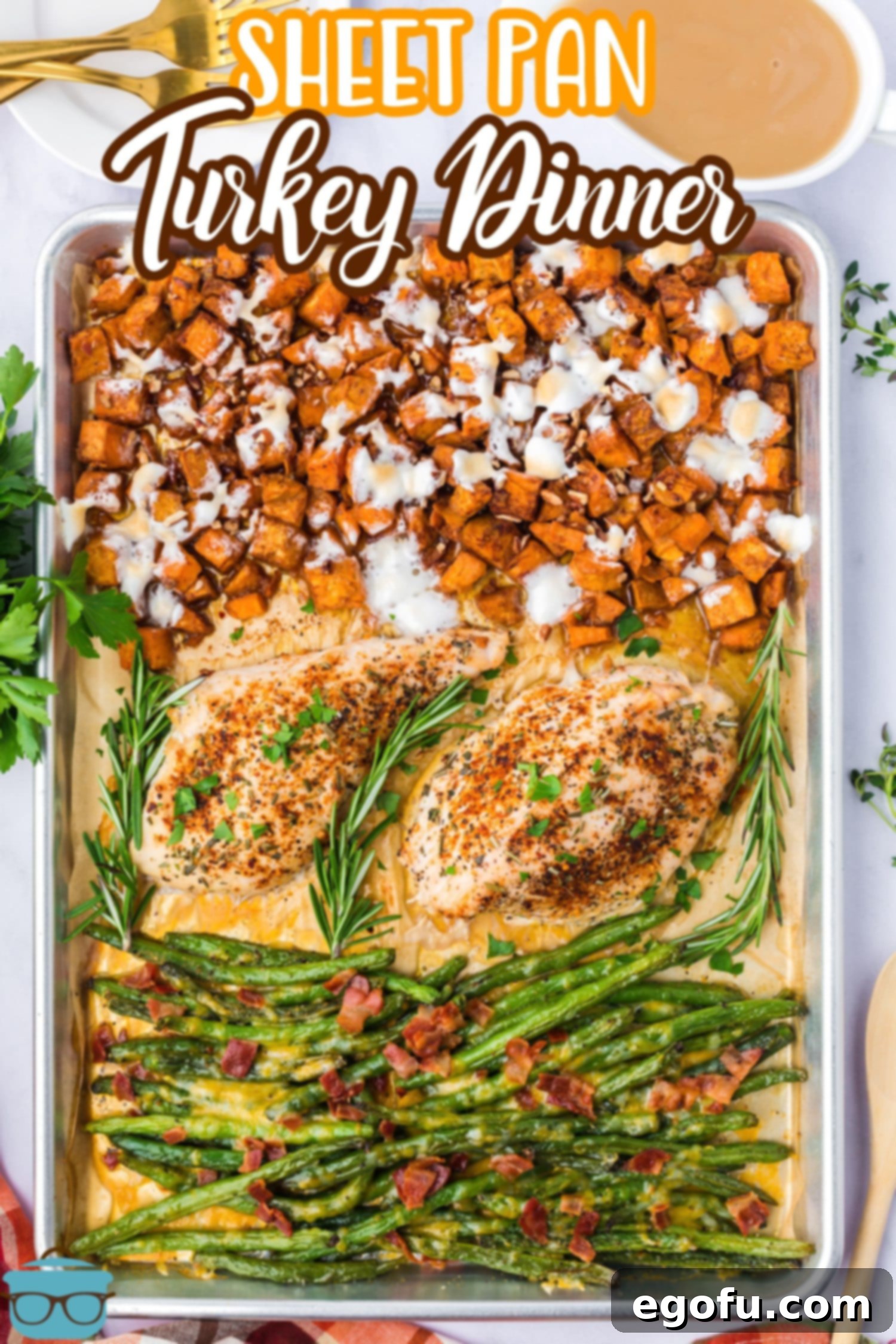 A close-up vertical shot of the Sheet Pan Turkey Dinner on parchment paper, showcasing the vibrant colors and textures.