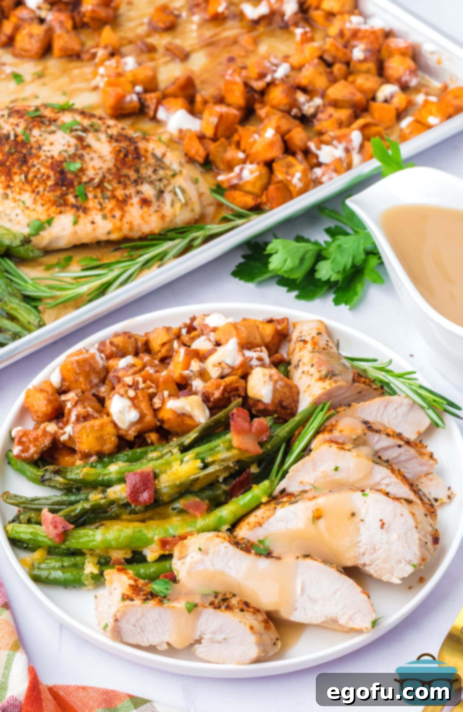 A beautifully plated serving of Sheet Pan Turkey Dinner with sliced turkey, sweet potatoes, green beans, and gravy.