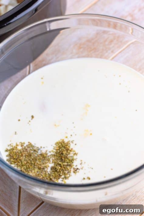 Cream of chicken soup, heavy cream, and Italian seasoning mixed in a bowl, ready to be added to the stew.