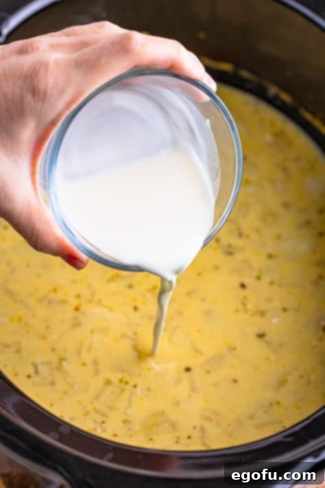 Cornstarch slurry being added to a slow cooker stew.