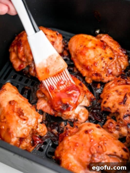 A basting brush basting chicken with more sauce.