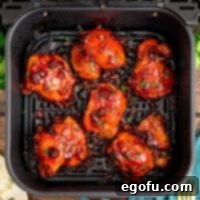 An Air Fryer basket with Air Fryer Cranberry Chicken Thighs.