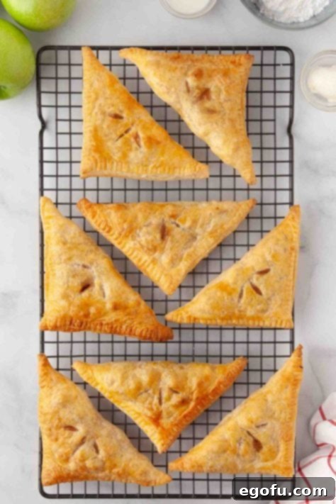 Apple turnovers cooling on a rack after baking.