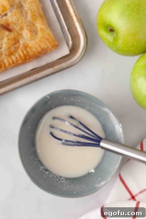 Sugar, milk, and cream cheese being whisked together for the glaze.