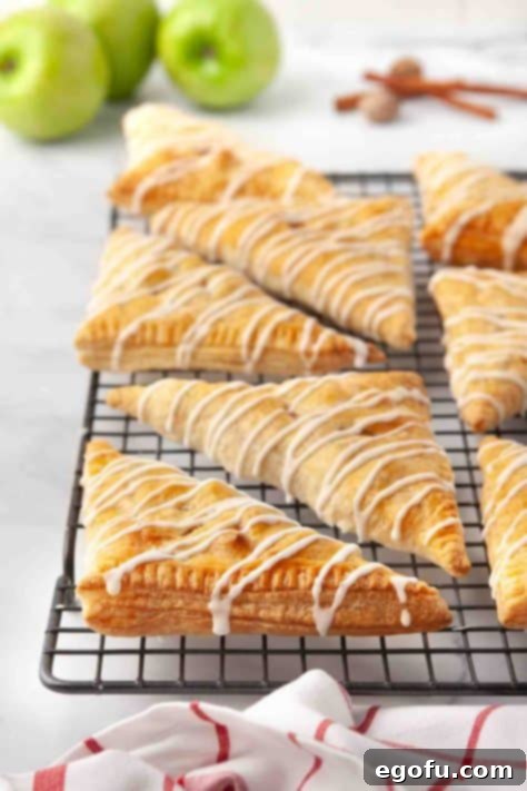 Glazed Apple Turnovers on a rack, showing the final touch.
