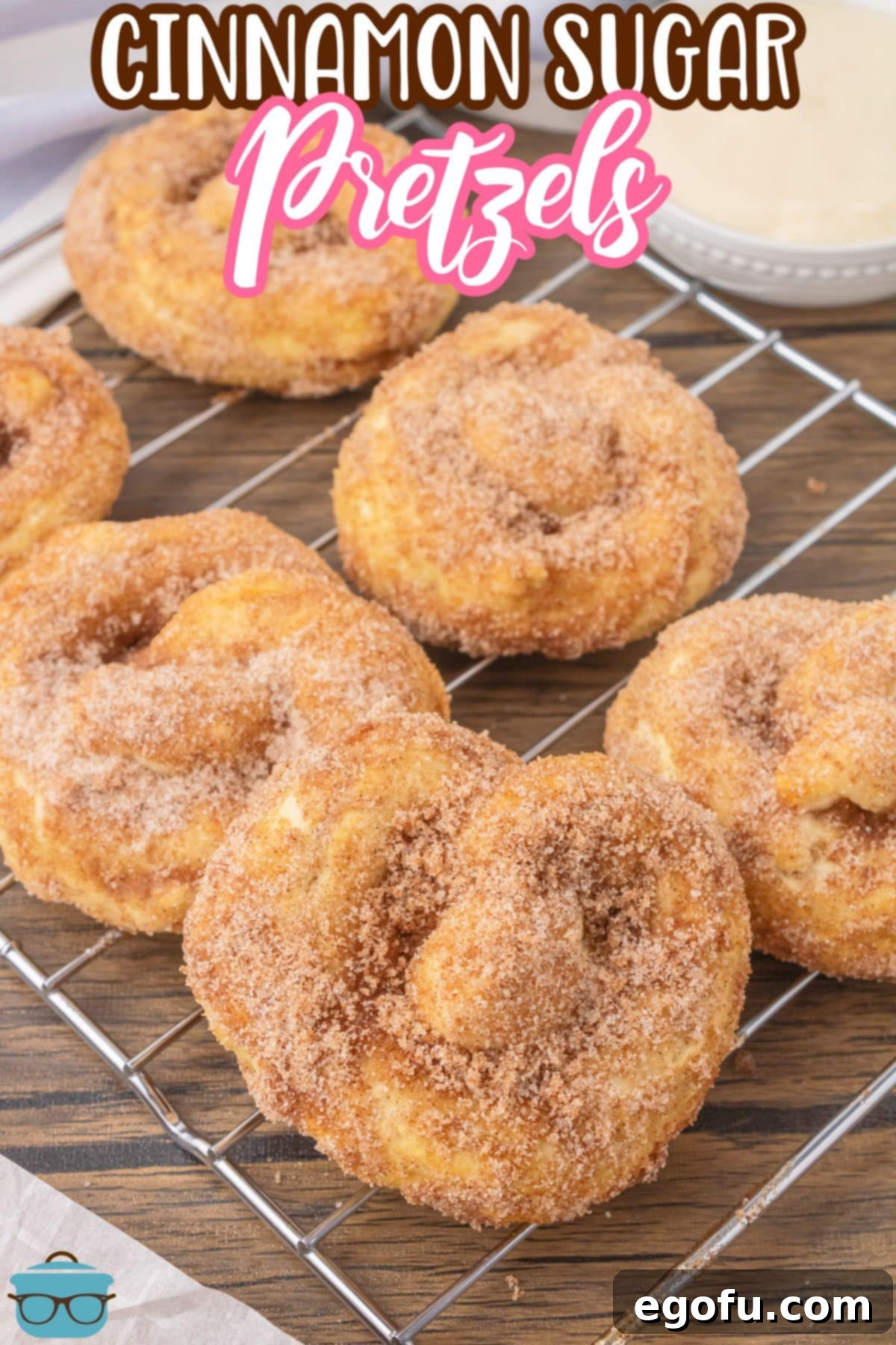 A wire rack filled with several homemade cinnamon sugar pretzels, cooling after being baked and coated.