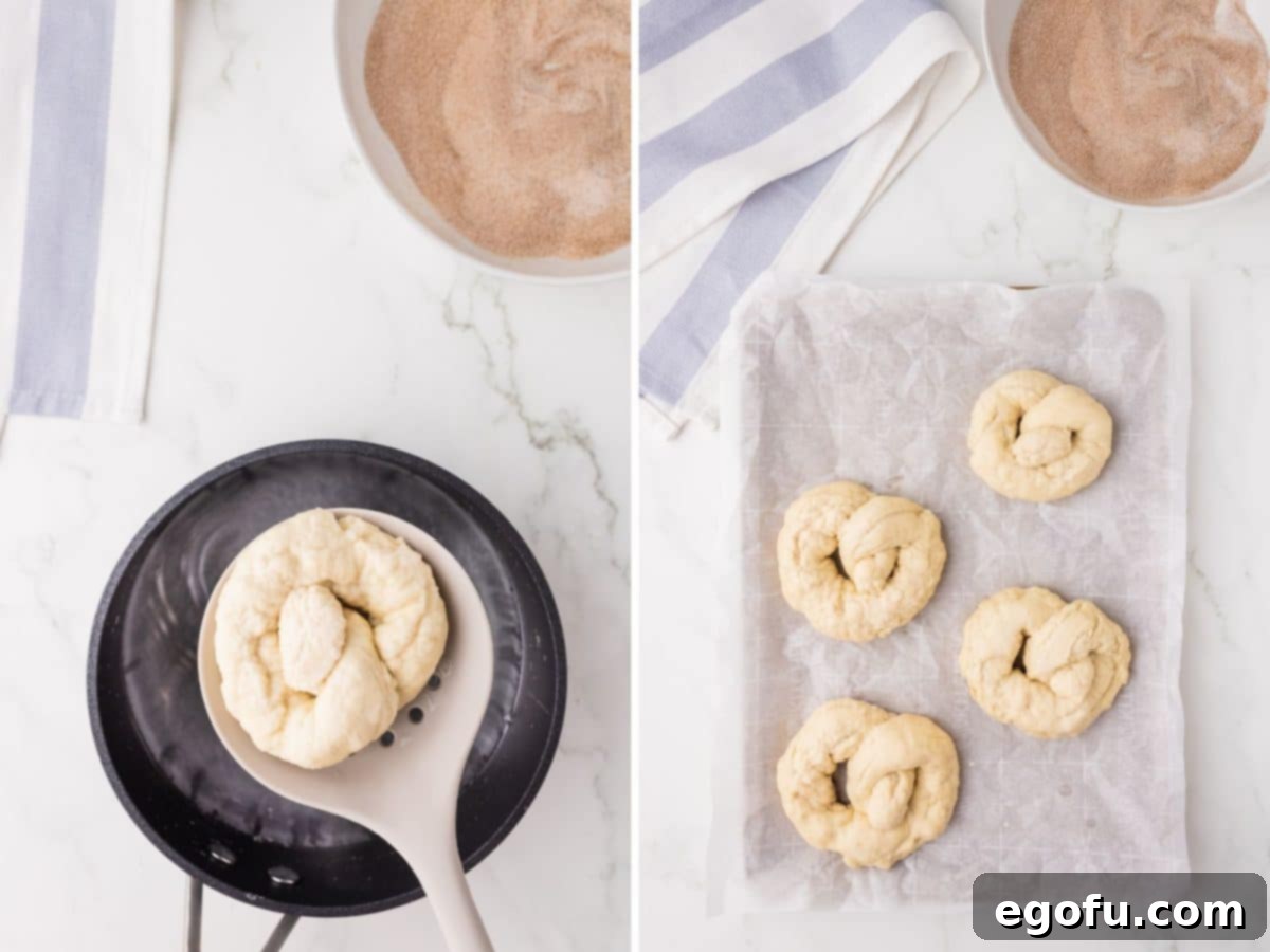 A spatula holding an unboiled pretzel above the pan, while a few boiled pretzels rest on a baking sheet.
