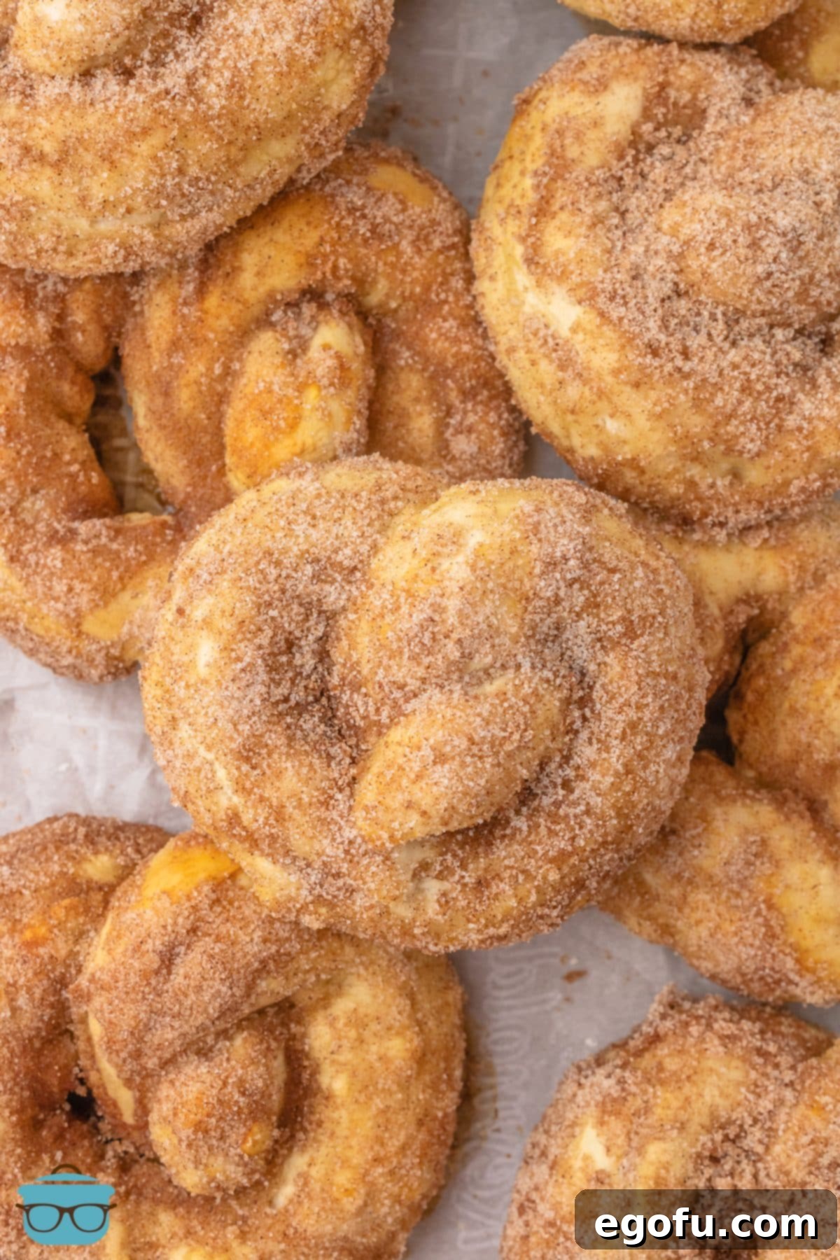 A top-down view of a pile of freshly made homemade Cinnamon Sugar Pretzels, dusted with the sweet coating.