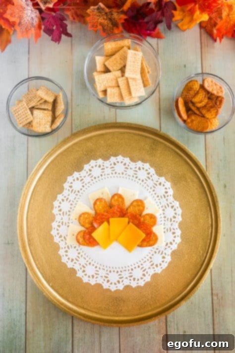 Pretzel crackers, cheese and pepperoni in semi circles on a plate.