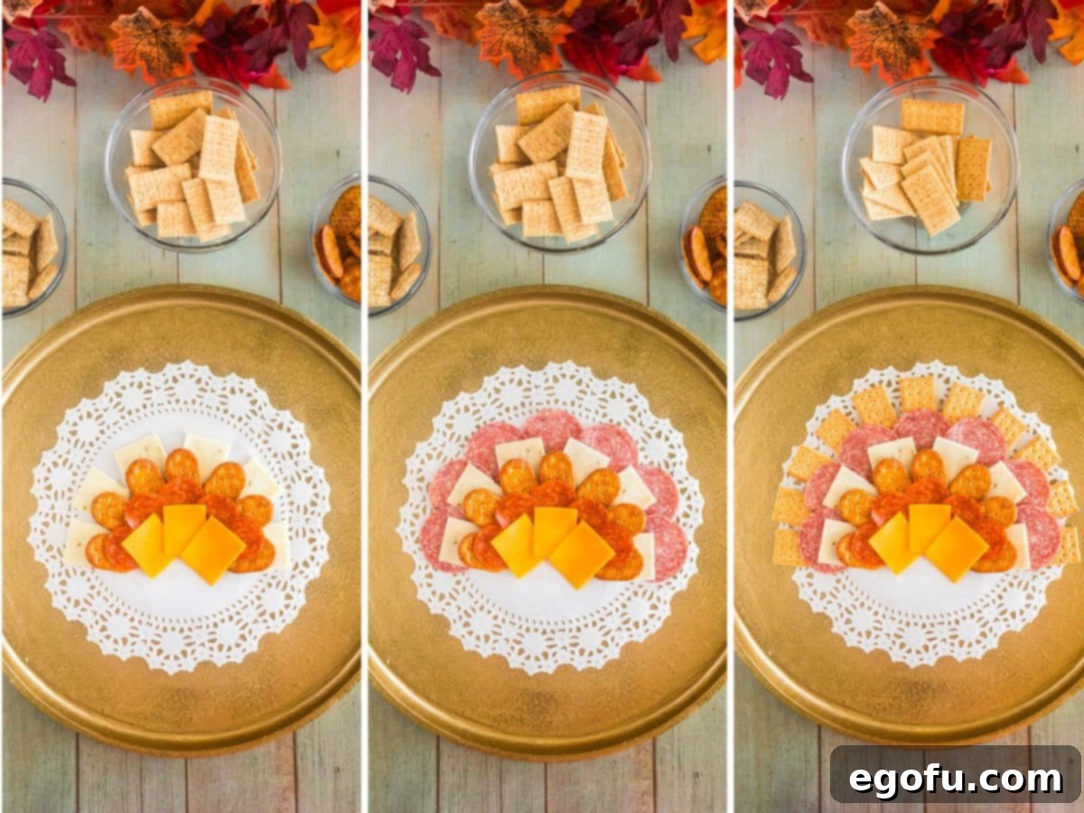 Subsequent layers of pepper jack cheese, Genoa salami, and club crackers being added to the charcuterie board, progressively forming the turkey's tail.