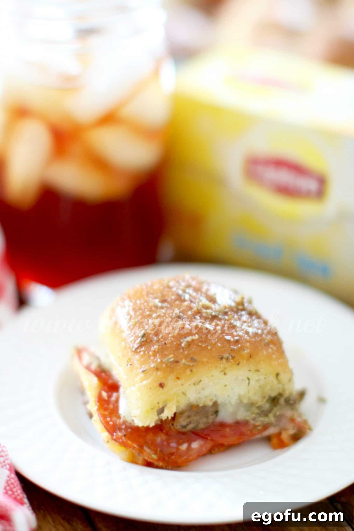 A single pizza slider presented on a small round white plate, ready to be enjoyed.