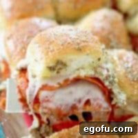 A close-up of a cooked pizza slider with melted cheese and toppings.