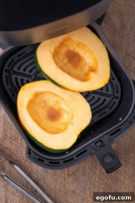 Perfectly Roasted Air Fryer Acorn Squash 12 A cut acorn squash in an Air Fryer basket.