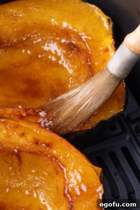 Perfectly Roasted Air Fryer Acorn Squash 13 A basting brush brushing a butter mixture on an acorn squash.