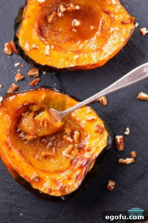 Perfectly Roasted Air Fryer Acorn Squash 14 Looking down on an Acorn Squash cut in half with a fork holding a bite.