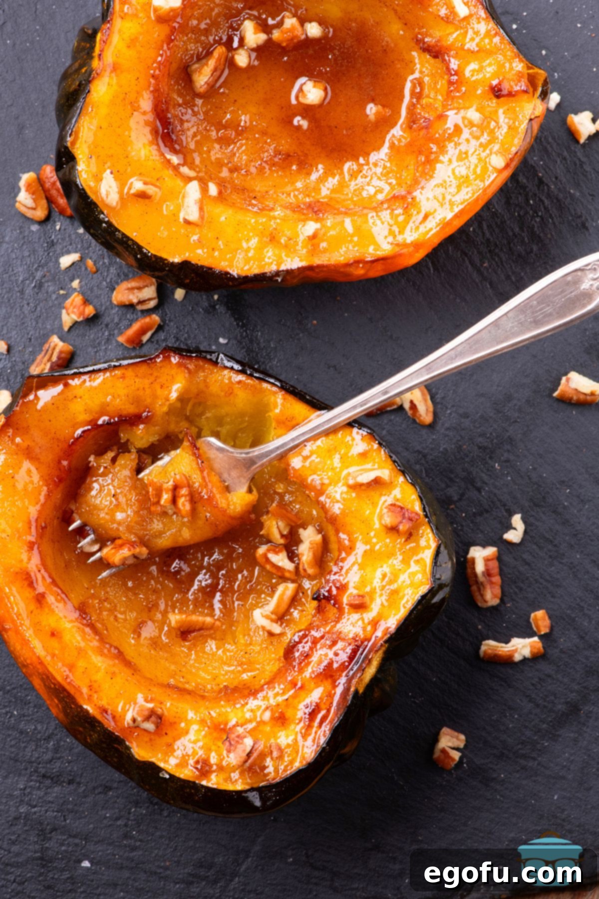 Perfectly Roasted Air Fryer Acorn Squash 8 Looking down on an Acorn Squash cut in half with a fork holding a bite, showcasing the tender, caramelized interior of the perfectly cooked dish.