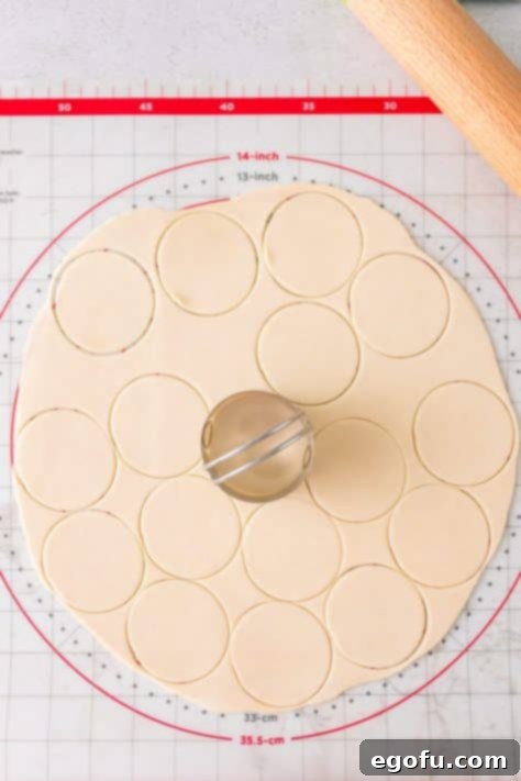 A cookie cutter cutting out circles on a pie crust.