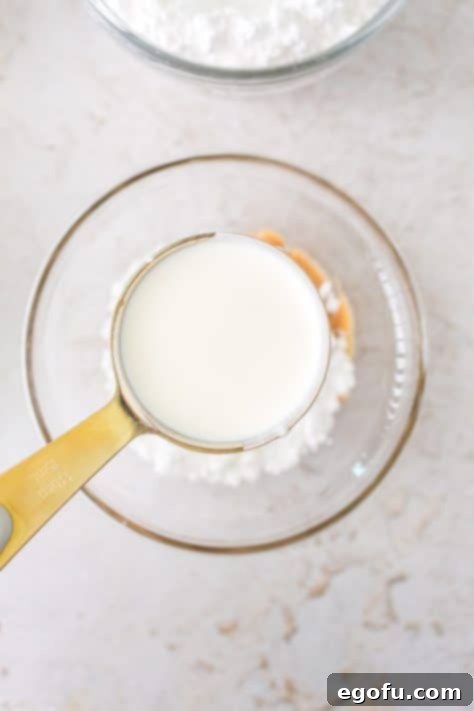 Heavy cream being added to powdered sugar and peanut butter.
