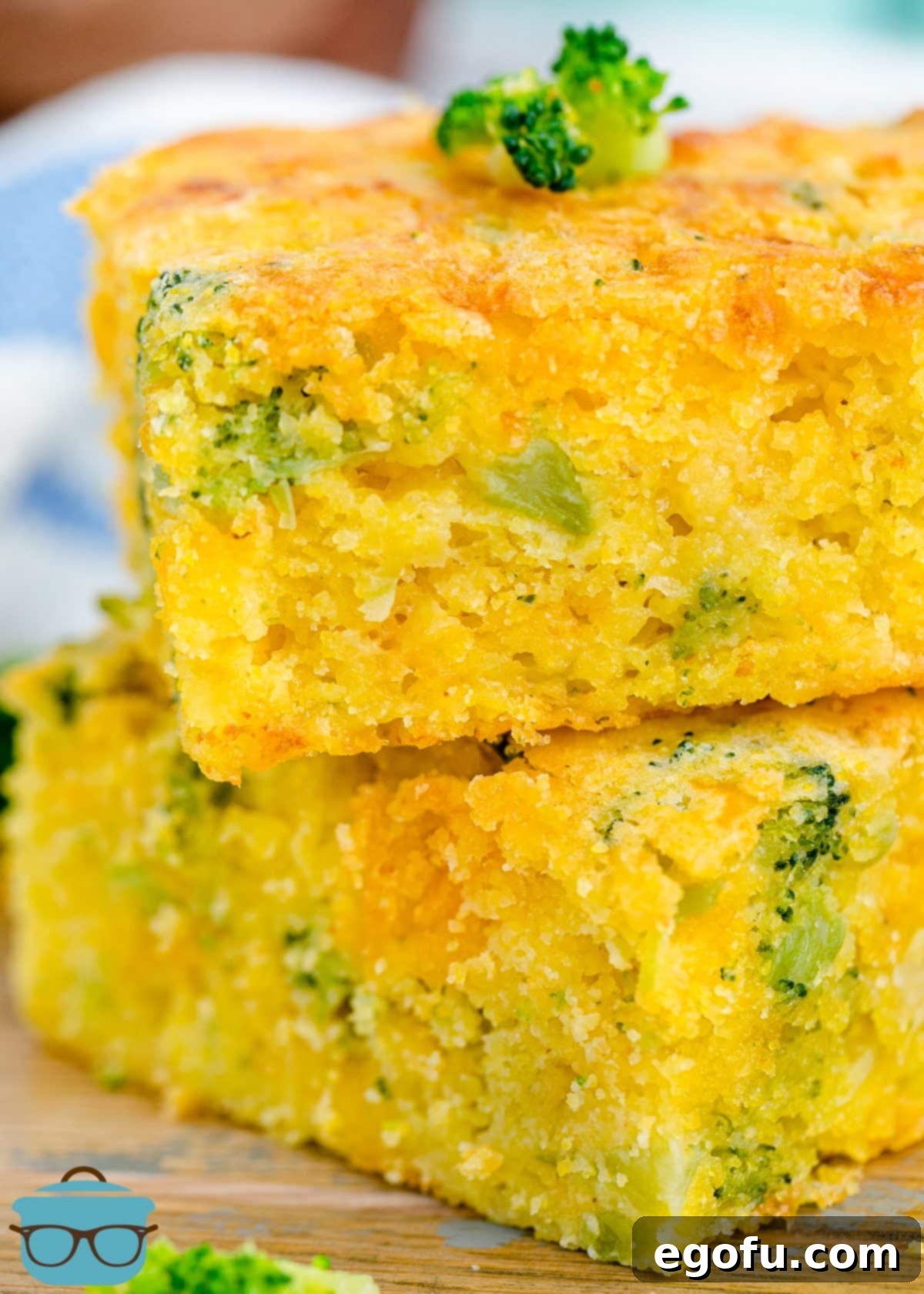 Homestyle Broccoli Cheddar Cornbread 2 Two pieces of moist and cheesy Broccoli Cheddar Cornbread, stacked on a plate.