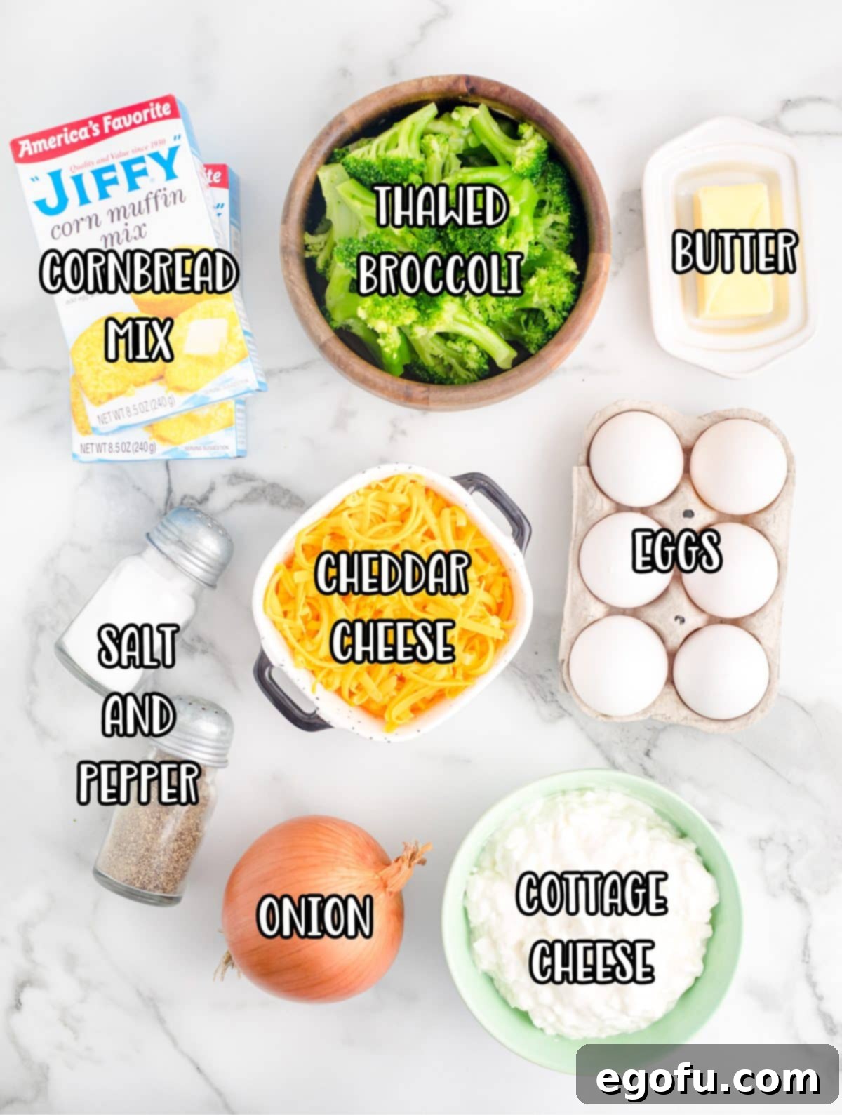 Homestyle Broccoli Cheddar Cornbread 5 A beautiful flat lay of all the fresh ingredients needed for Broccoli Cheddar Cornbread, including cornbread mix, butter, eggs, shredded cheese, onion, cottage cheese, thawed broccoli, salt, and pepper.