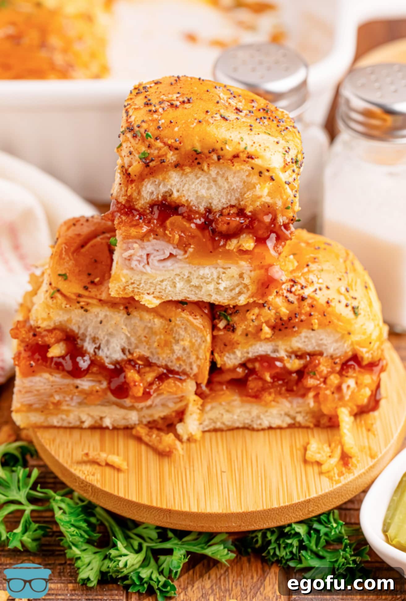 Zesty BBQ Chicken Sliders 2 A small stack of BBQ Chicken Sliders on fluffy Hawaiian Rolls, garnished with fresh parsley.