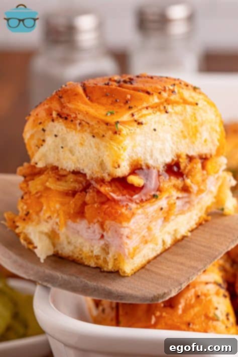 Zesty BBQ Chicken Sliders 17 Closely looking at a BBQ Chicken Slider on a wooden spatula.