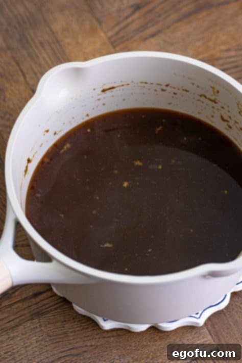 A pot of simmering au jus gravy, prepared from a mix and water.