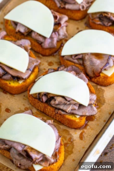 Additional cheese slices placed on top of roast beef and cheese on Texas Toast.