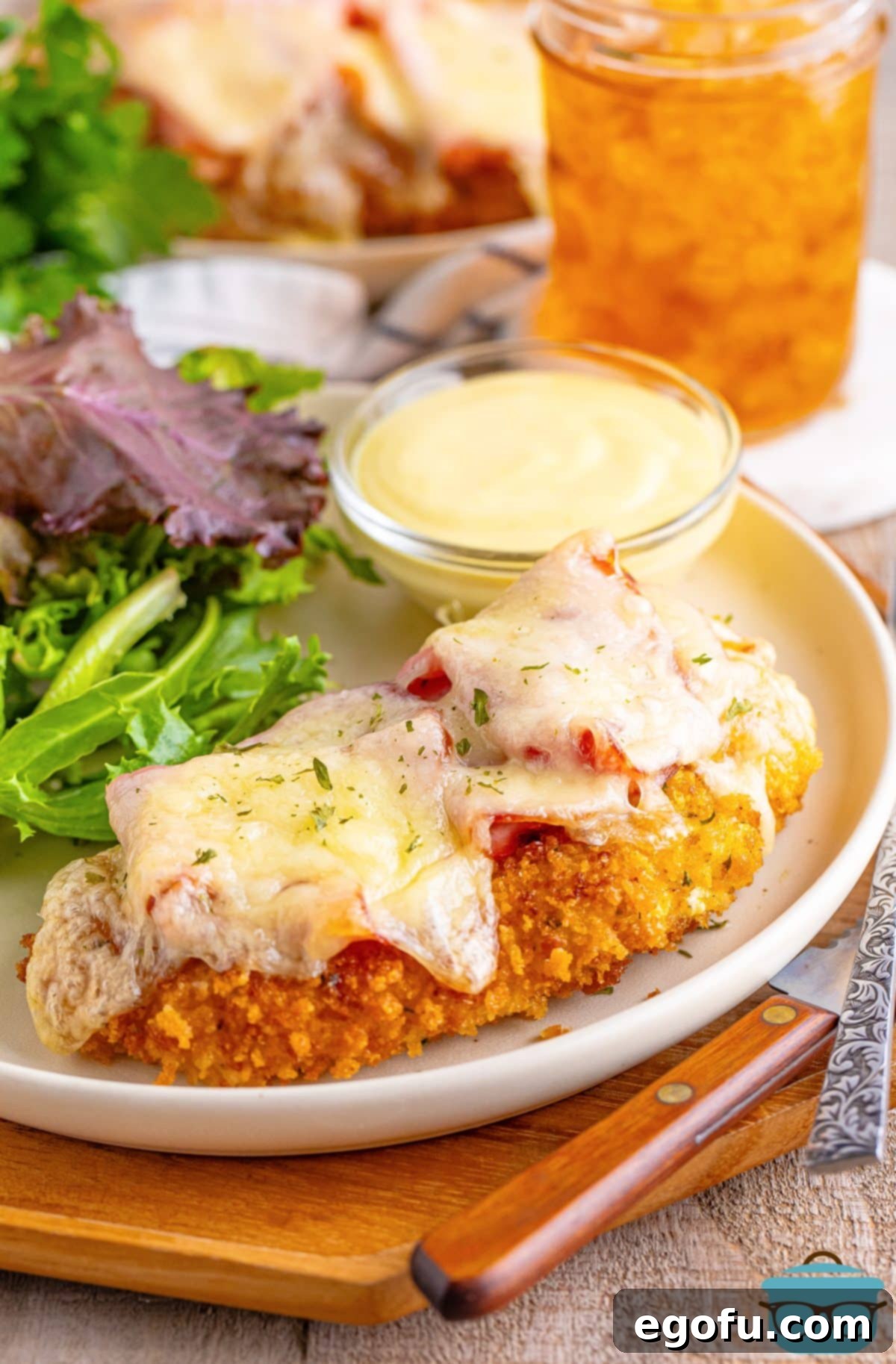 California Stuffed Chicken 2 Two pieces of Malibu Chicken with side dishes on a plate.